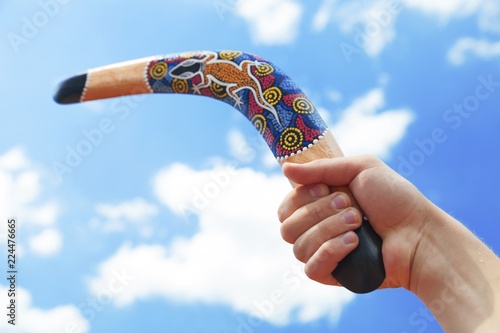 Wooden Boomerang with Blue Sky and Cloud Background photo
