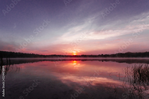 Beautiful  pink violet dawn over the lake. Fog over the lake  the rays of the sun  very dense fog  dawn  the blue sky over the lake  the morning comes  the forest reflects in the water.