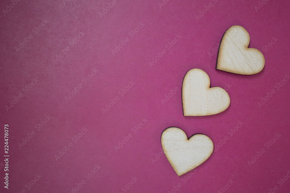 Obraz premium Decorative white wooden hearts on crimson paper. Template greeting card for wedding or Valentine's Day. copy space