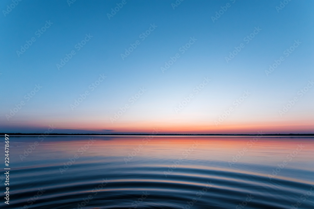 Obraz premium ircles on the water against a beautiful, pink sunset. The magic time of day.