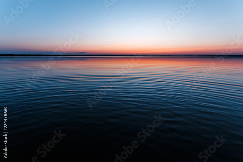 Fototapeta Naklejka Na Ścianę i Meble -  ircles on the water against a beautiful, pink sunset. The magic time of day.