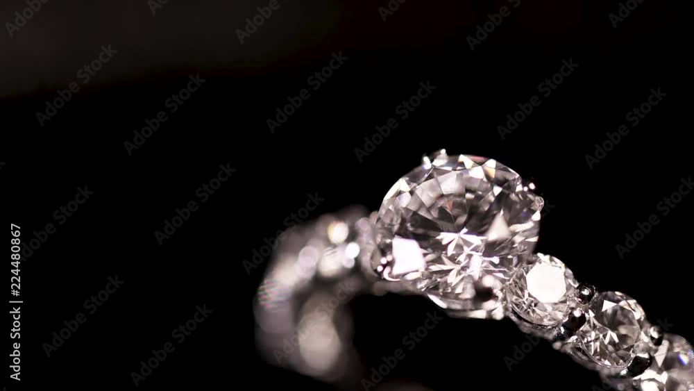 Engagement diamond ring rotating on black background, macro with shallow DoF Engagement diamond ring rotating on black background, macro with shallow DoF