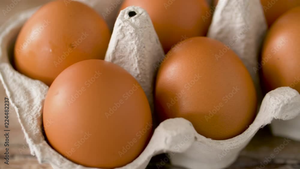 food, culinary and cooking concept - close up of natural chicken eggs in cardboard box on wooden table food, culinary and cooking concept - close up of natural chicken eggs in cardboard box on wooden table