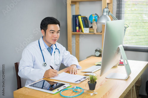 Photography Stethoscope with clipboard and Laptop on desk,Doctor working in hospital writing