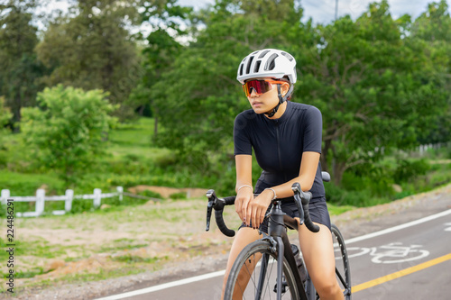 Cycling,A young cyclist sitting relax on a bicycle saddle after the race. Sports women bikes in the morning,vintage color,selective focus, sports concept,low angle view,Business competition