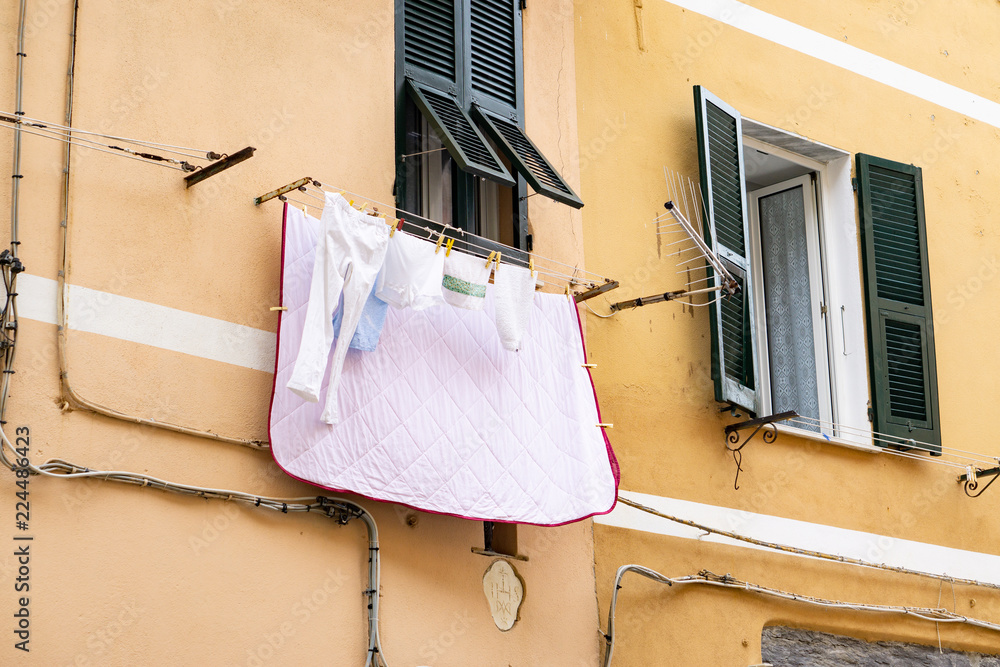 Rope with clean clothes hanging to dry on a clothes-line, outdoors. Italian street.italy Rope with clean clothes hanging to dry on a clothes-line, outdoors. Italian street.italy