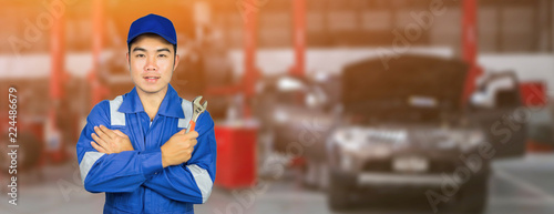 Photography Asian Thai Technician repairing the car in garage,mechanics fixing in a workshop suspension detail of lifted automobile at service station,vintage color