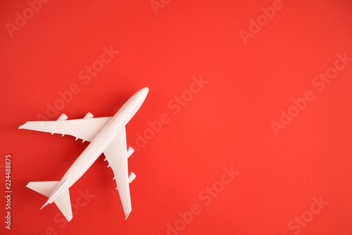 Airplane model. White plane on red background. 