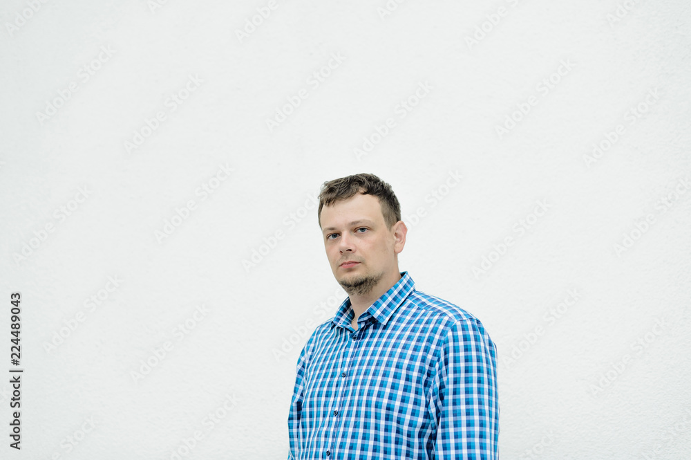 portrait of a young man with disheveled hair, with a beard, dressed in a blue checkered shirt portrait of a young man with disheveled hair, with a beard, dressed in a blue checkered shirt