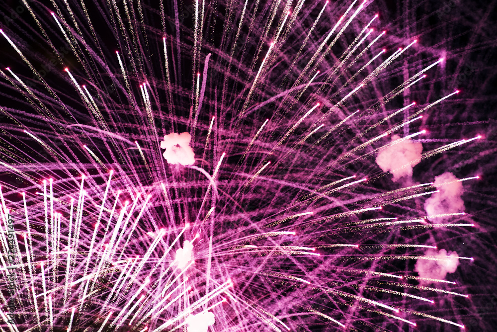 Obraz premium Salute in the night sky. Bright texture of festive fireworks. Abstract holiday background with various colors fireworks light. New Year's, Christmas lights in the sky, colorful lights.