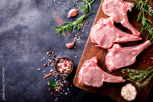 Meat Raw Fresh Mutton on the bone Spices Chesno and Rosemary on a black background  Top View Copy space for Text photo