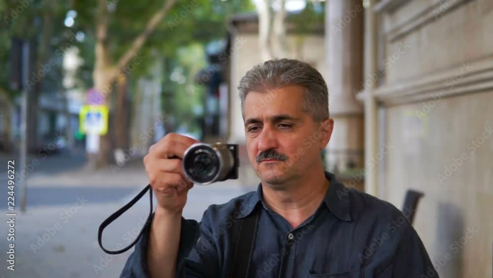 Photographer man taking photo on mirrorless camera Photographer man taking photo on mirrorless camera