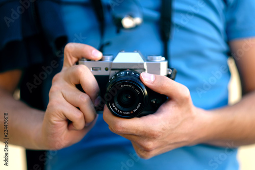 Close up, unrecognizable tourist man is holding an retro camera. Selective focus. © Ridvan