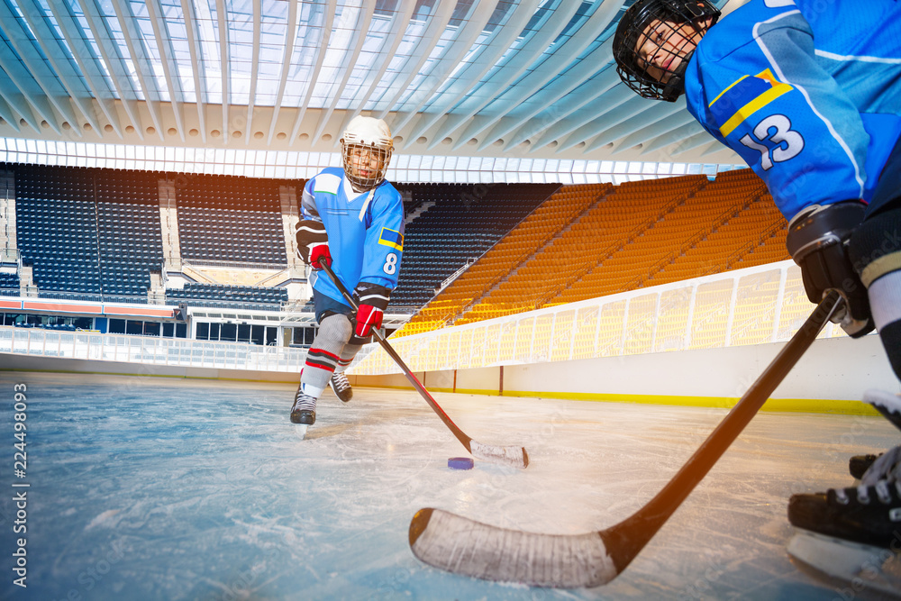 Fototapeta premium Boys passing puck during hockey training session