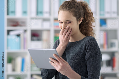 фотографія Happy woman using a tablet and giggling