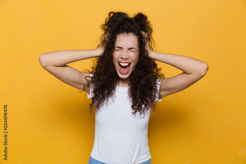 Screaming excited young cute woman posing isolated over yellow background. - obrazy, fototapety, plakaty 