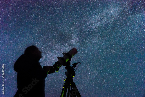 Fototapeta Silhouette of a woman with a telescope