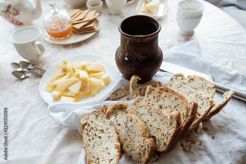 Breakfast in country house. Homemade baked bread, pitcher withmilk on table. photo