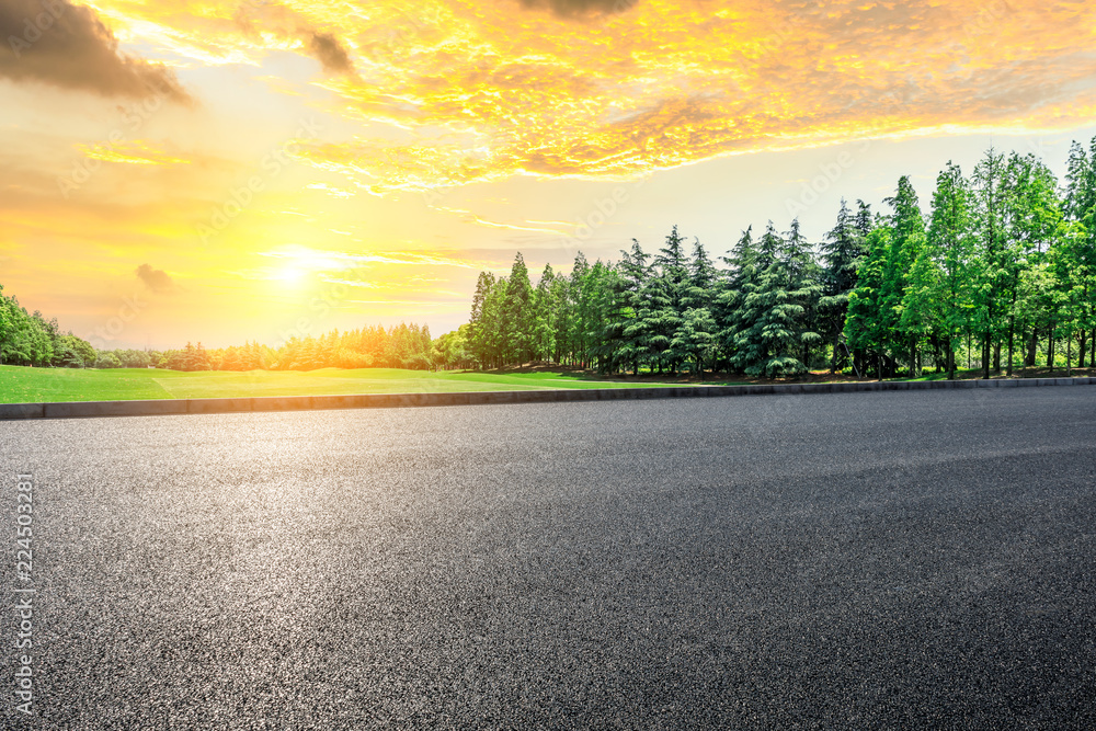 Empty asphalt road and green woods at sunset Empty asphalt road and green woods at sunset
