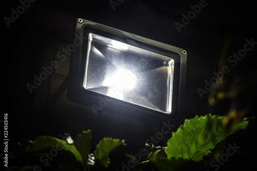 Fotografija Garden LED spotlight on a wooden building close-up.