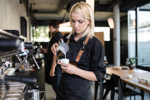 Young woman at barista school learning how to make espresso coffee. photo