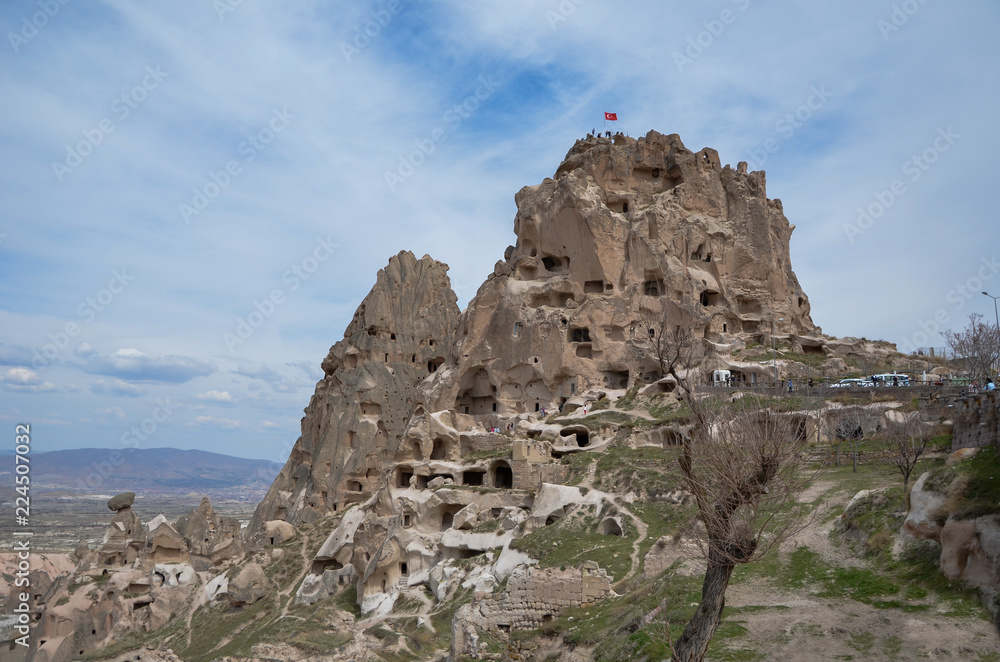 Uchisar Castle in Cappadocia Turkey, blue and cloudy sky.