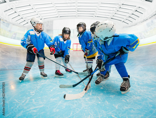 Children's ice hockey team practicing on rink