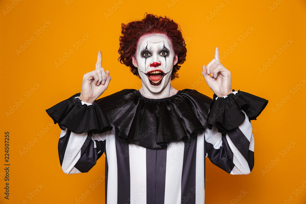 kam gå på pension Voksen Happy clown man 20s wearing black costume and halloween makeup looking at  camera, isolated over yellow background Stock Photo | Adobe Stock