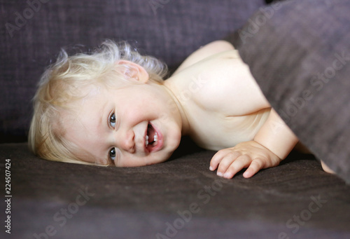 Petit Bebe Blond Aux Yeux Bleus Alonge Sur Le Canape Avec Un Joli Sourire Stock Photo Adobe Stock