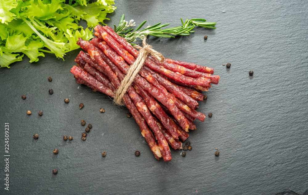 Food background. Snack stick sausages on a wooden table