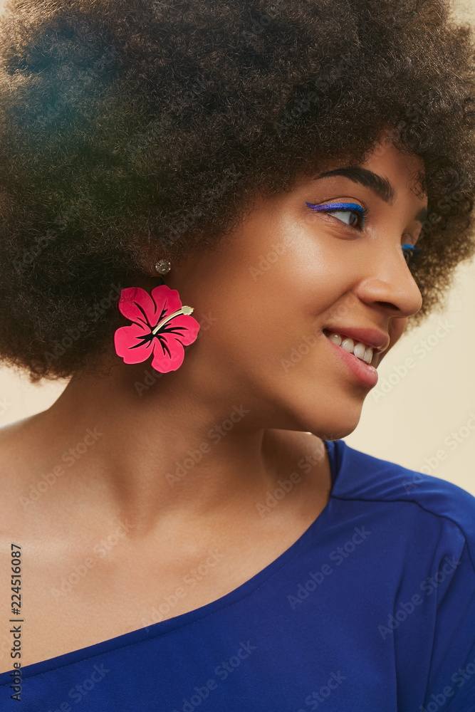 A close up portrait of a young African lady with short curly hair. The girl  in