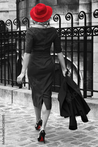 Young woman walking in Montmartre, Paris. Black and white photo with isolated red colour. 