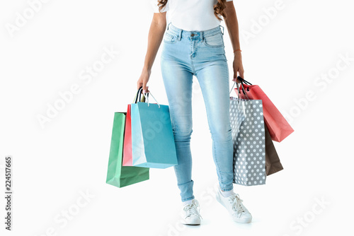 cropped view of woman posing and holding shopping bags, isolated on white