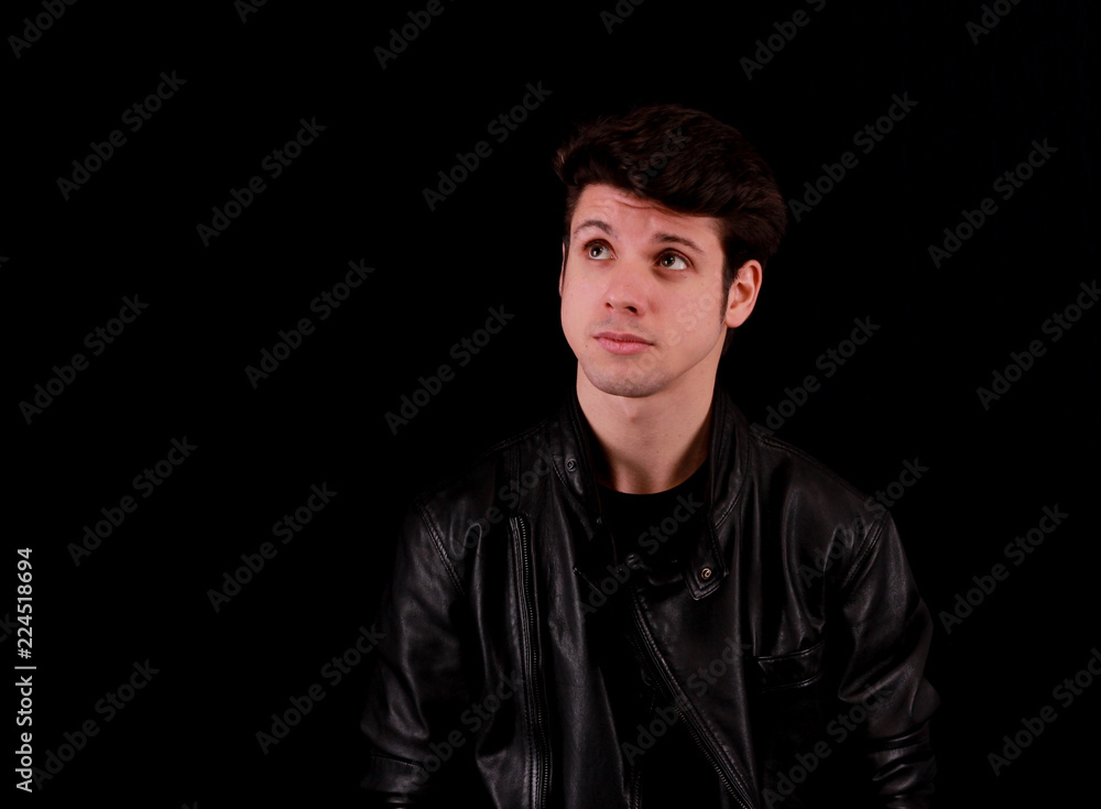 Thinking man standing in front of black background Thinking man standing in front of black background