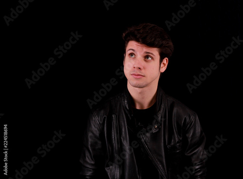 Thinking man standing in front of black background