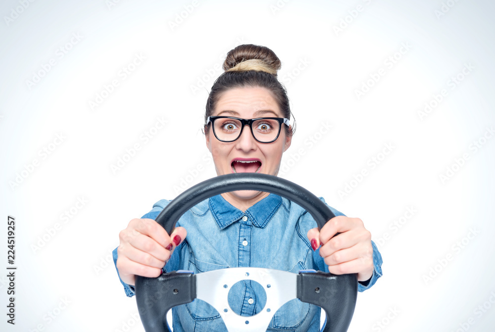 Happy screaming young girl with glasses and car steering wheel, front view, auto concept Happy screaming young girl with glasses and car steering wheel, front view, auto concept