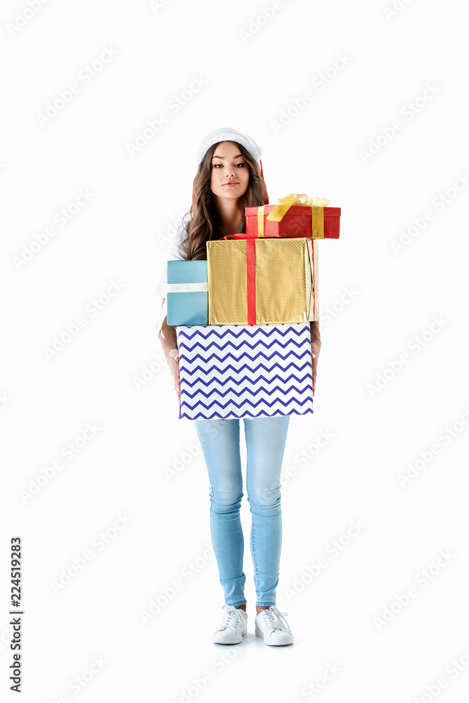 beautiful girl in santa hat holding christmas presents, isolated on white