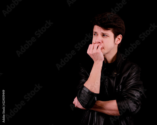 Handsome young man thinking in front of black background