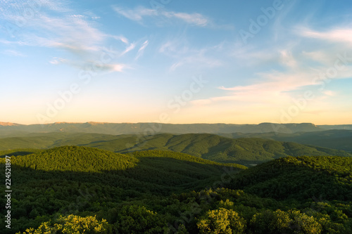Wooded mountains at sunset in summer evening