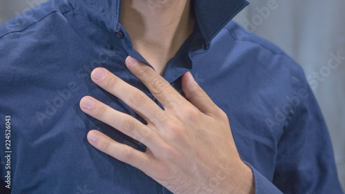 A close up on a hand of a man getting dressed into his radiant blue casual business attire for work.