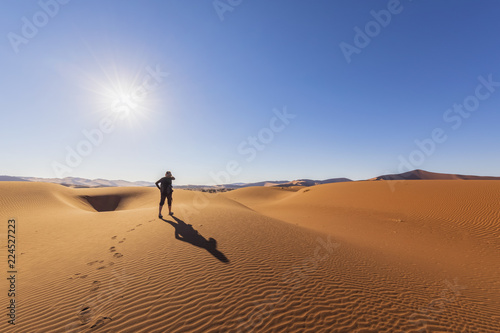 Africa, Namibia, Namib desert, Naukluft National Park, female tourist walking on dune