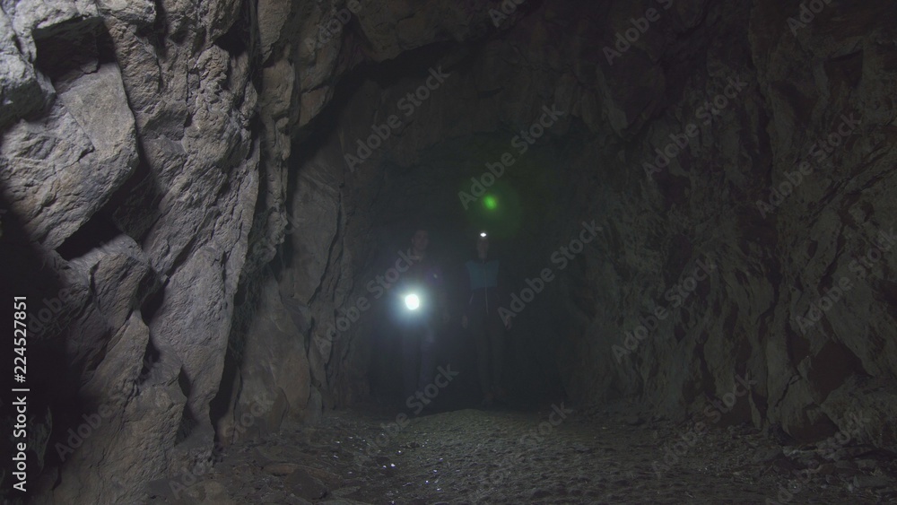 man and woman go with lanterns in the cave