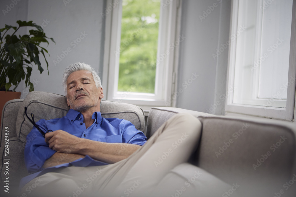 Portrait of mature man relaxing on couch at home Portrait of mature man relaxing on couch at home