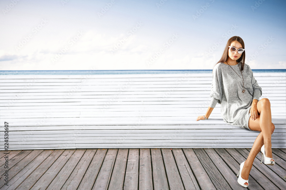 Slim young woman on wooden pier and autumn landscape of sea Slim young woman on wooden pier and autumn landscape of sea