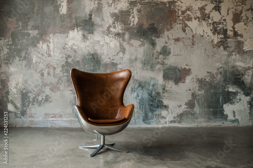 Loft interior mock up photo. Gray textured wall with leather armchair. Background photo with copy space for text. Horizontal