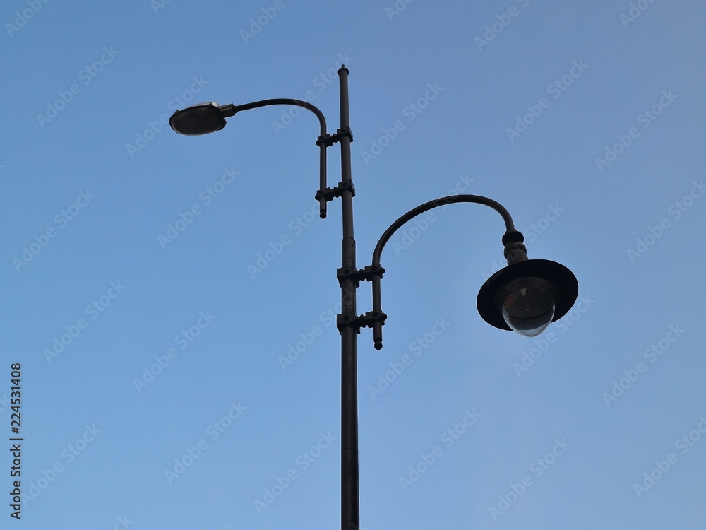 A street lamp with two lights against a blue sky, bottom view A street lamp with two lights against a blue sky, bottom view