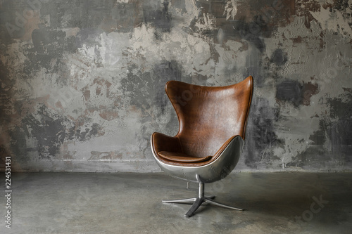 Loft interior mock up photo. Gray textured wall with leather armchair. Background photo with copy space for text. Horizontal photo