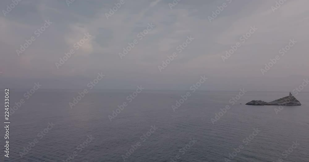 Aerial view at dawn of a lighthouse on the summit of a rocky islet without vegetation in front of Portoferraio, Elba island (Italy) Aerial view at dawn of a lighthouse on the summit of a rocky islet without vegetation in front of Portoferraio, Elba island (Italy)