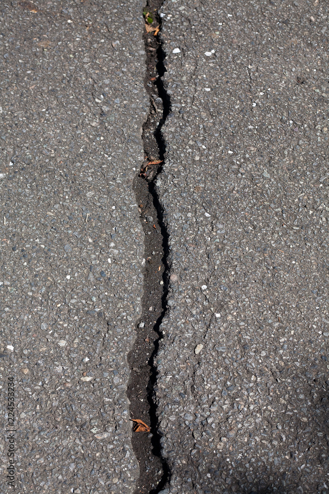 Obraz premium Straight crack in asphalt road