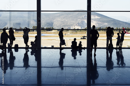 Silhouettes of people near a window in the airport of the city of Bodrum. Turkey. Waiting for the flight home after a rest at the resort.